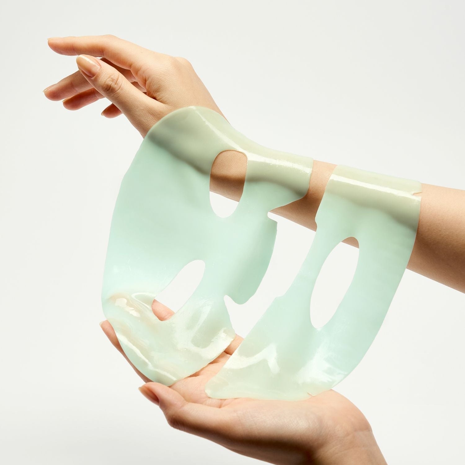 Décris l'image en français : LUVUM Green Citrus Vitamin C Gel Mask Plus 5 Sheets, mains appliquant des masques gel verts.