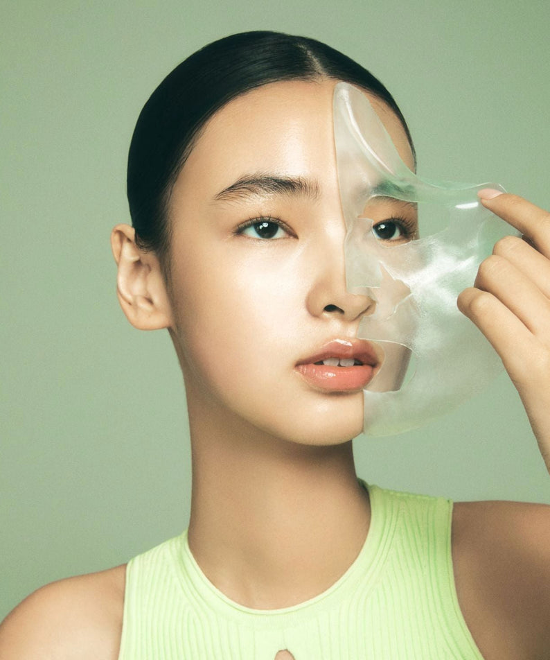 LUVUM Green Citrus Vitamin C Gel Mask Plus 5 Sheets, marque LUVUM : jeune femme applique un masque gel vert sur visage.