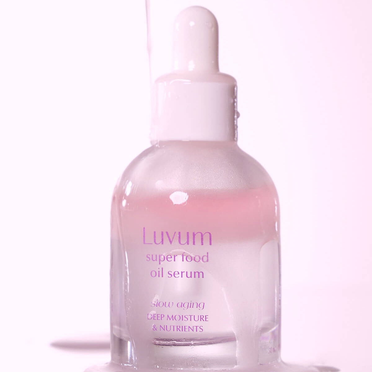 Décris l'image en français: LUVUM Slow Aging Super Food Oil Serum 30ml de la marque Luvum, sérum huile en flacon rose sur fond clair.
