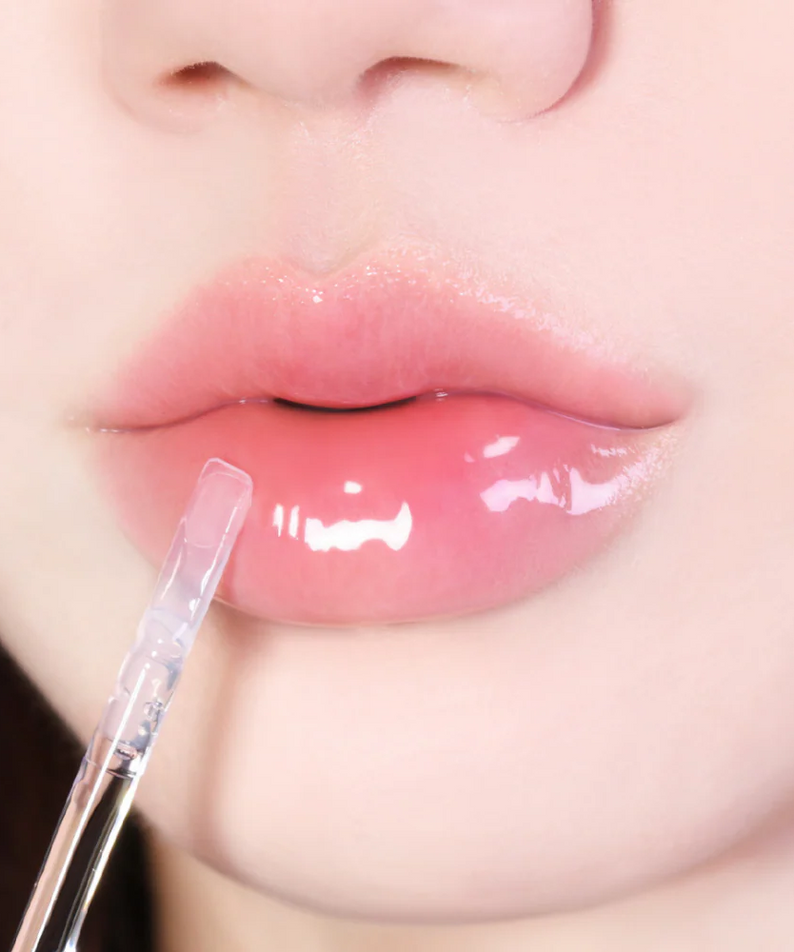 Décris l'image en français : LUVUM Volume Lip Serum 4ml, marque LUVUM, sérum pour lèvres en application sur des lèvres.
