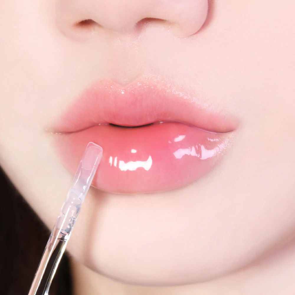 Décris l'image en français : LUVUM Volume Lip Serum 4ml, marque LUVUM, sérum pour lèvres en application sur des lèvres.