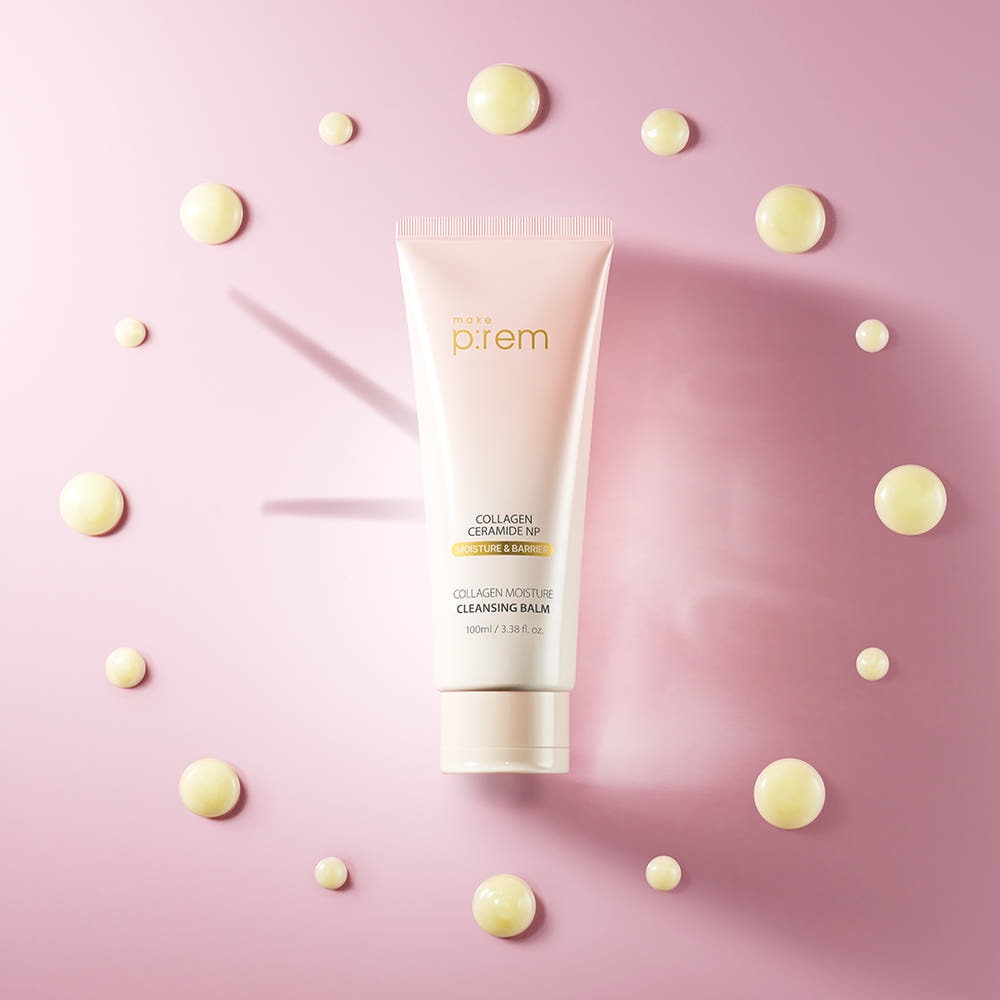 MAKE P:REM  Collagen Moisture Cleansing Balm 100ml sur fond rose, tube et perles dorées décoratives (marque MAKE P:REM)