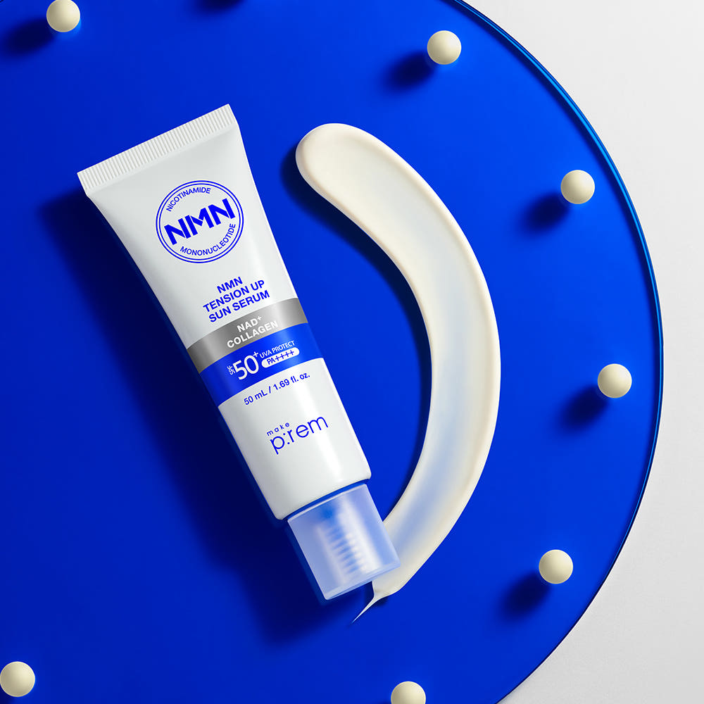 MAKE P:REM NMN Tension Up Sun Serum SPF 50+ PA++++ 50ml, tube crème solaire sur fond bleu décoré de points.