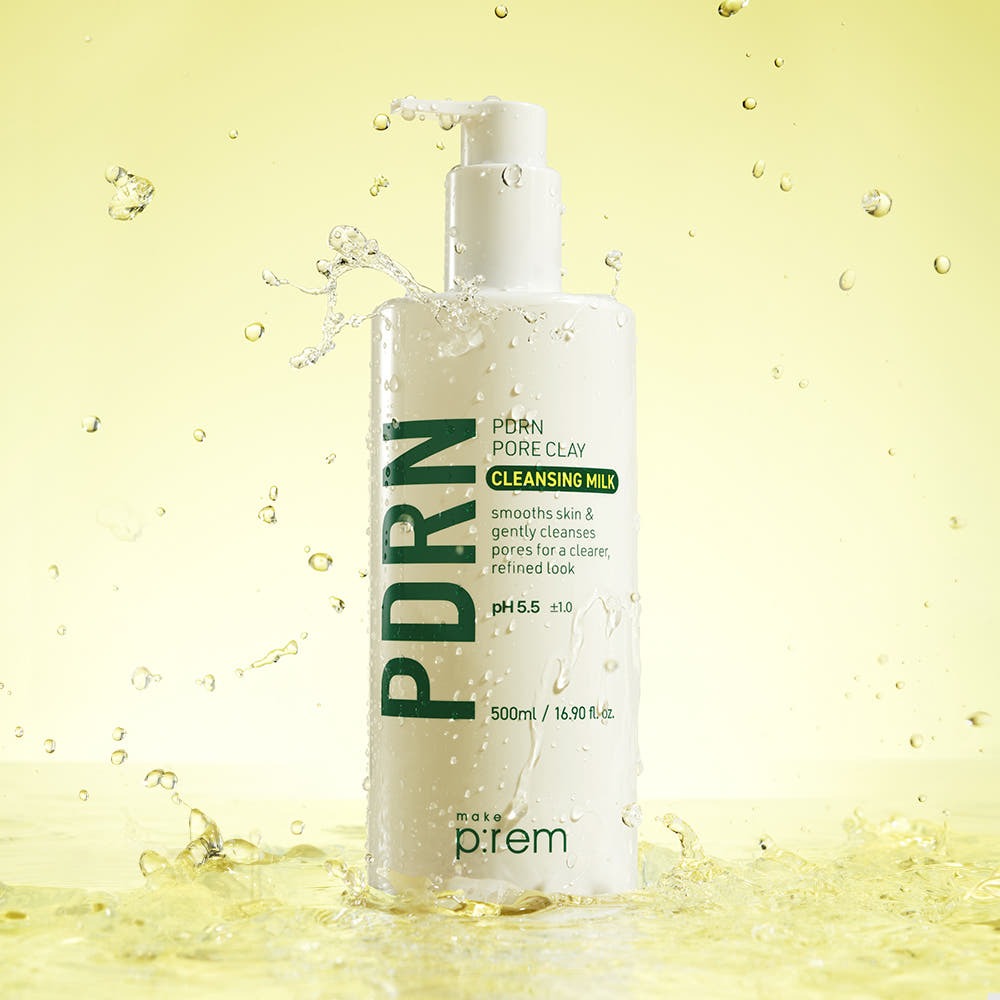 MAKE P:REM PDRN Pore Clay Cleansing Milk 500ml, flacon en image produit sur fond jaune avec éclaboussures d’eau