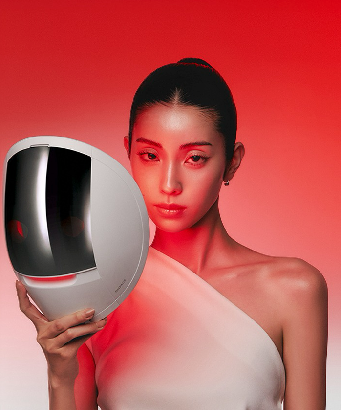 MAKEON Onface LED Mask de la marque, masque LED sur fond rouge, portrait beauté avec modèle en studio.