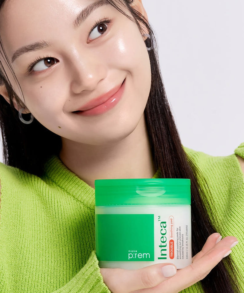 Femme souriante tenant MAKE P:REM Inteca Trouble Soothing Pads 70 sheets, produit apaisant pour la peau.