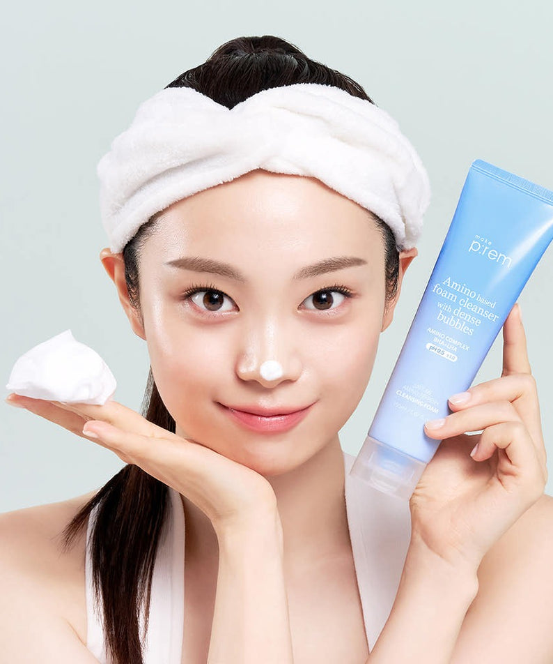 Femme souriante utilisant MAKE P:REM Safe Me Amino Refresh Cleansing Foam 150ml, nettoyant doux pour une peau fraîche.
