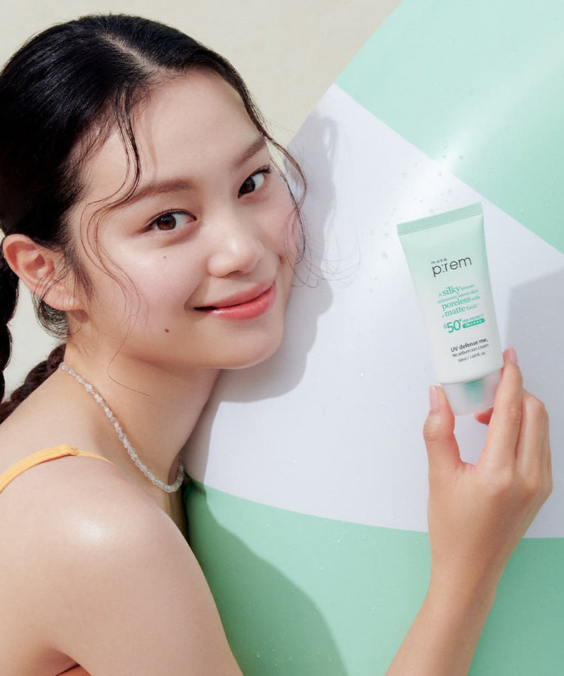 Femme souriante tenant MAKE P:REM UV Defense Me No-Sebum Sunscreen 50ml, idéal pour la protection solaire et le contrôle du sébum.