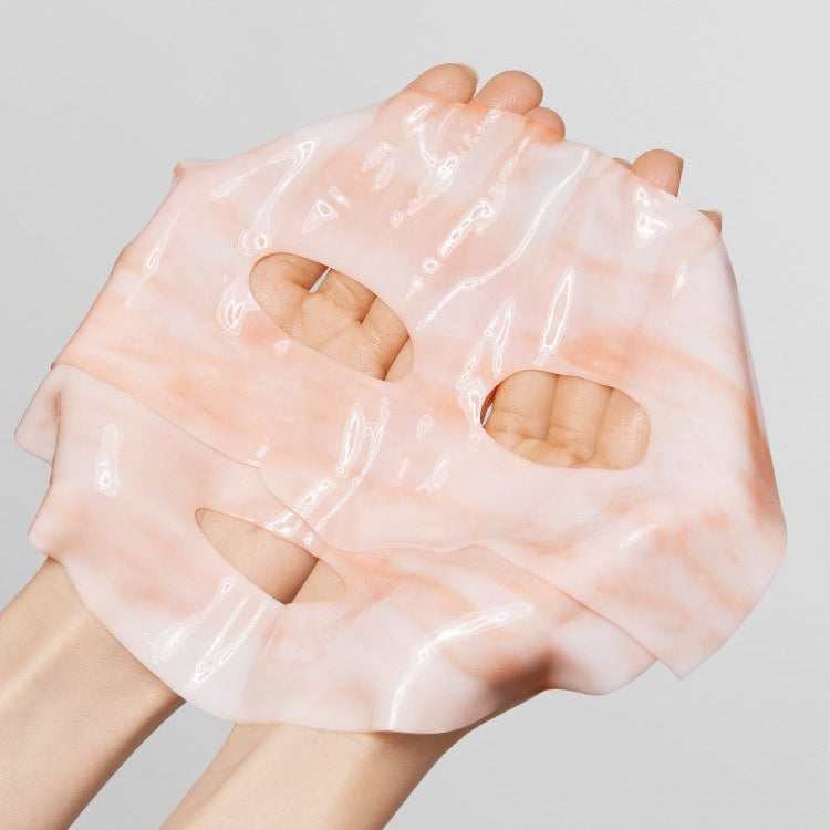 MAMONDE Flora Glow Rose Marble Pack : mains tenant un masque tissu rose marbré, style cosmétique sur fond clair.