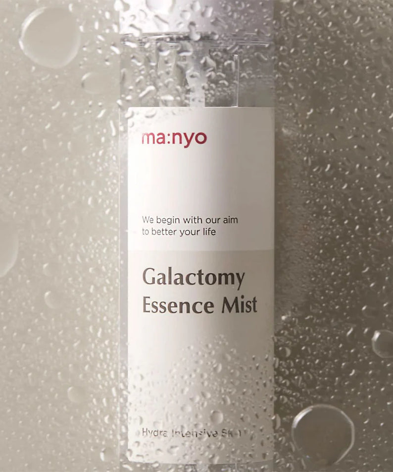 MANYO Galactomy Essence Mist 120ml en gros plan avec gouttelettes d'eau sur la bouteille, montrant l'effet hydratant du produit.