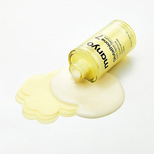 Décris l'image en français: MANYO Glutathione 7 Dark Spot Serum 30ml, crème blanche et flacon jaune MANYO sur fond clair.