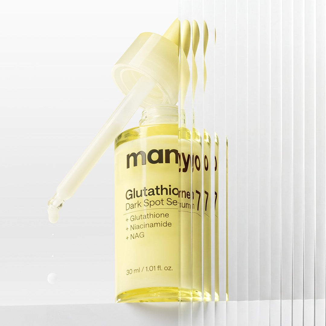 MANYO Glutathione 7 Dark Spot Serum 30ml, sérum anti-taches MANYO en flacon jaune sur fond blanc, goutte à l’avant