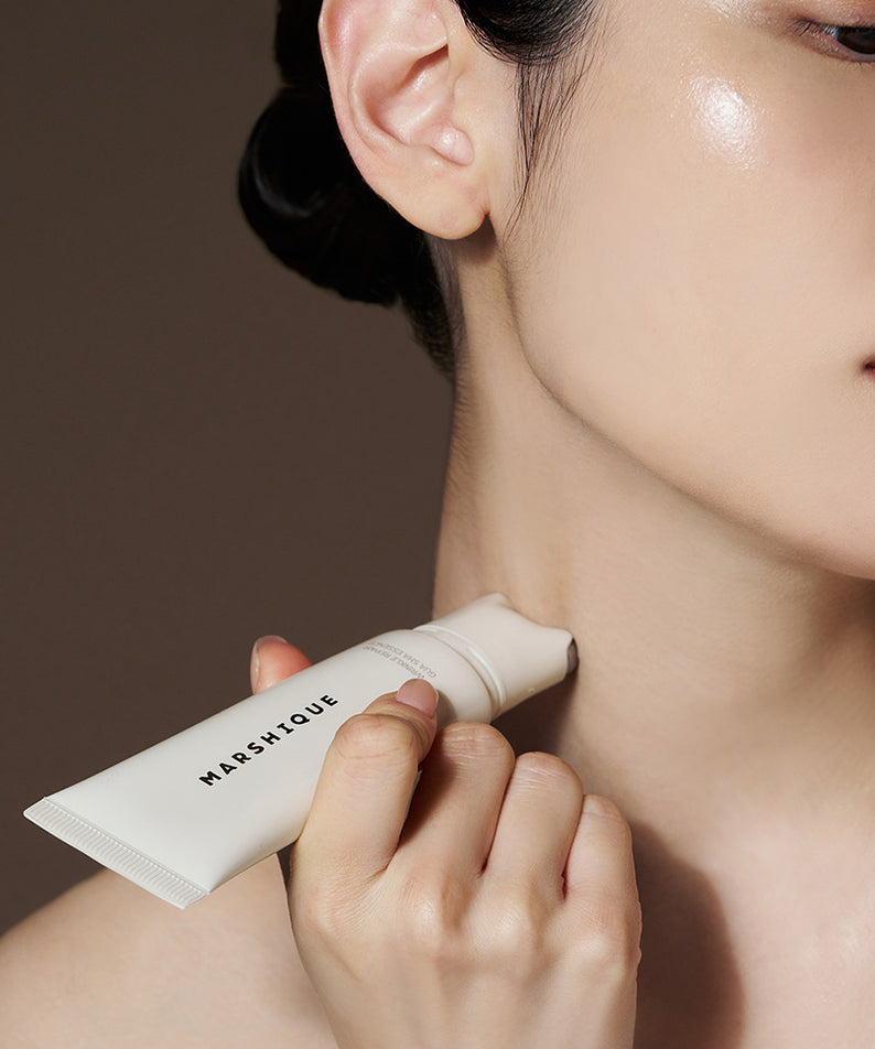 Décris l'image en français : MARSHIQUE Wrinkle Repair Guasha Essence 45ml, flacon appliqué sur le visage, marque MARSHIQUE.