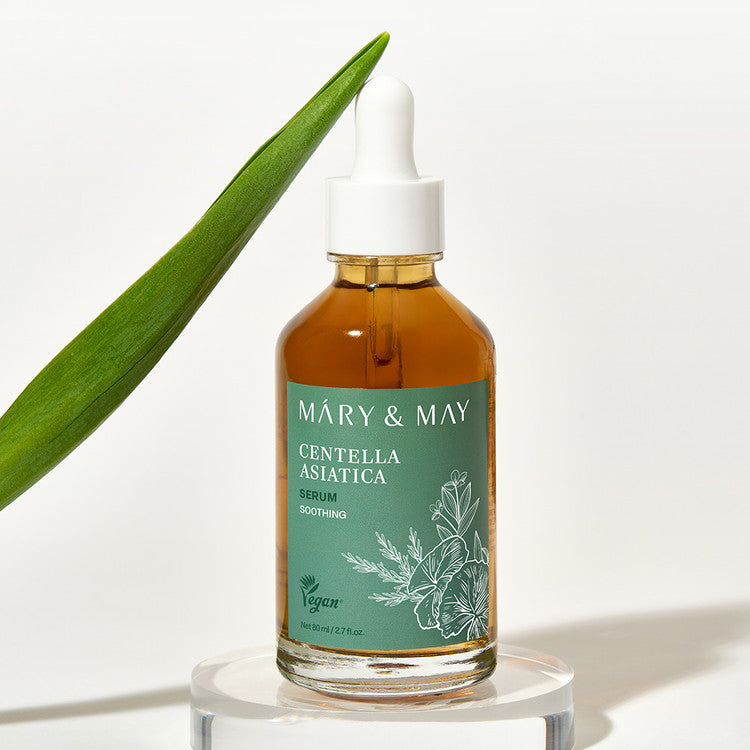 MARY&MAY Herbal Extract Serum 80ml, flacon sur socle, aloe vert en arrière-plan, marque MARY&MAY, contexte cosmétique.