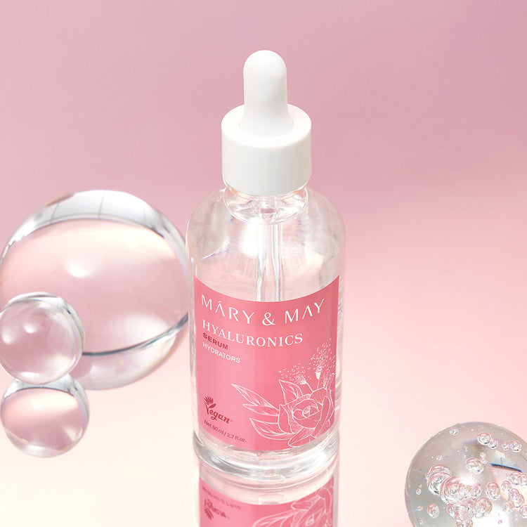 MARY&MAY Hyaluronic Serum 80ml, sérum hydratant en flacon sur fond rose, gouttes et capsules, visuel produit de la marque