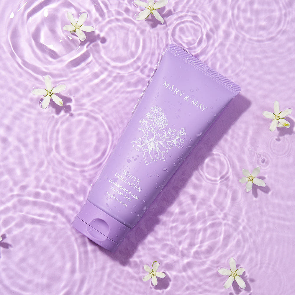 MARY&MAY White Collagen Cleansing Foam 150ml, tube sur fond violet fleuri, marque en gros plan, texture mousse