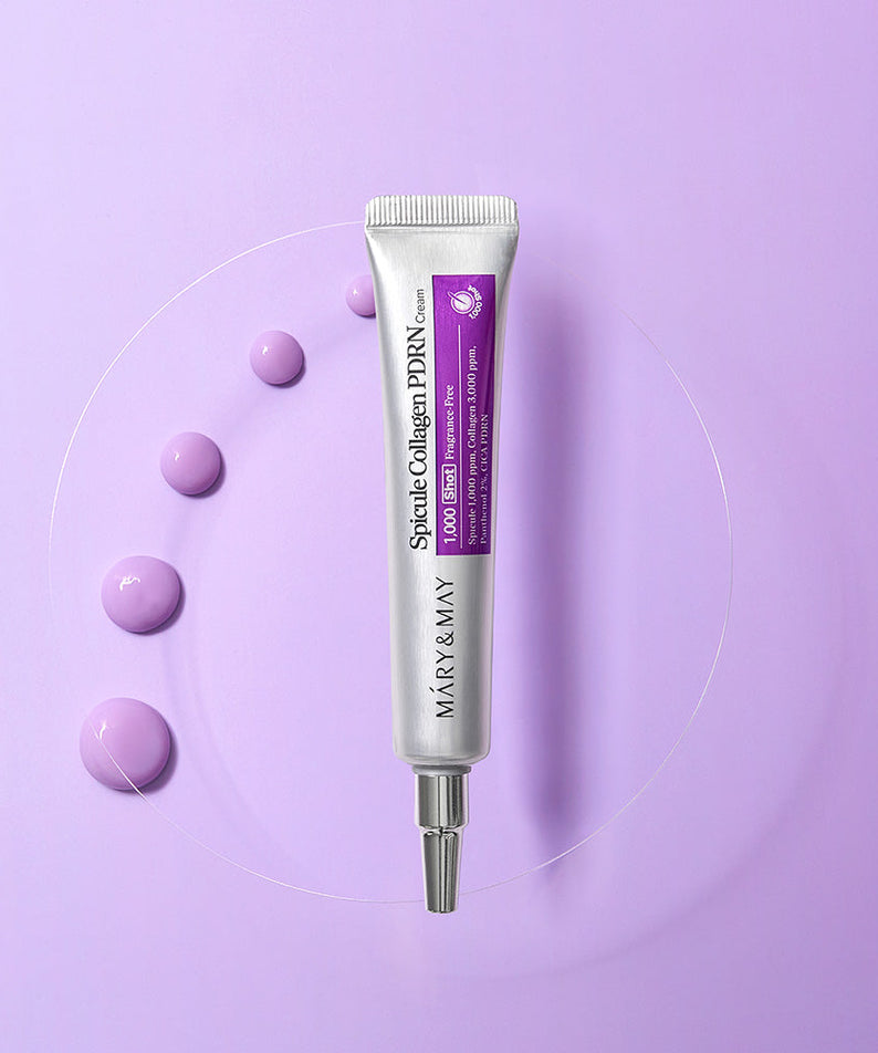 Tube de MARY&MAY Speckle Collagen PDRN Cream 15g sur fond violet avec gouttes de crème, produit de soin de la peau.