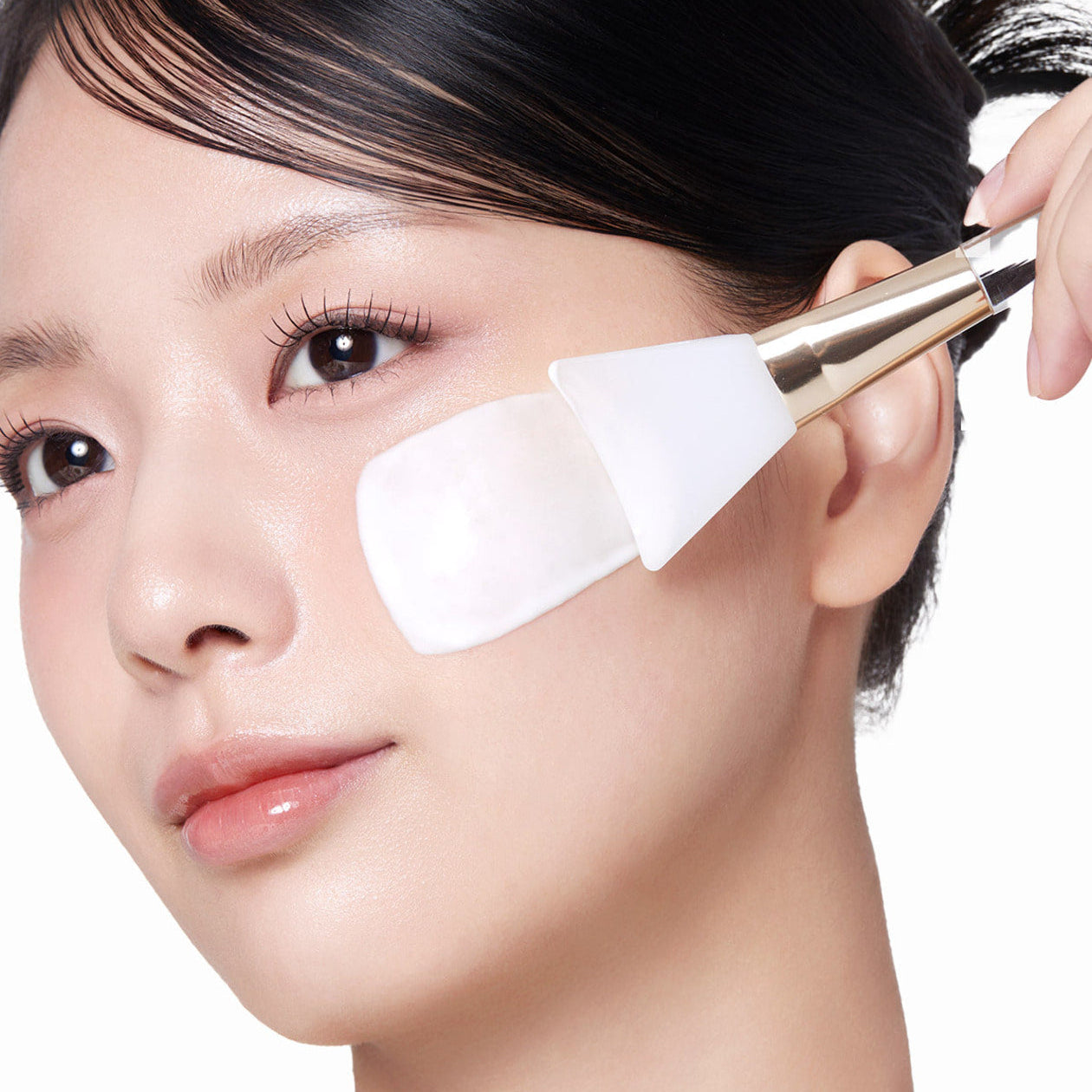 Appliquer MEDICUBE Collagen Milk Wrapping Mask 80ml : une femme avec une spatule, marque et soin visage en gros plan.
