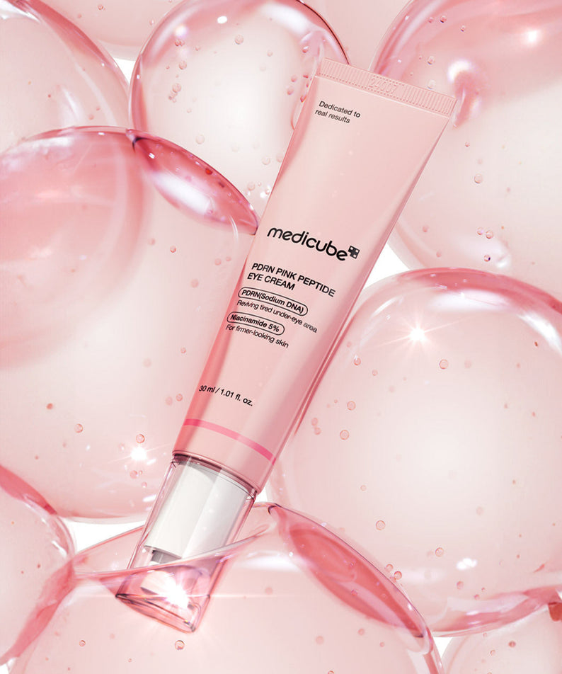 Crème pour les yeux MEDICUBE PDRN Pink Peptide Eye Cream 30ml sur fond rosé avec bulles, soin raffermissant et hydratant.