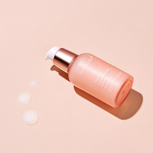 MEDICUBE Triple Collagen Serum 4.0, flacon rose à l’aspect cuivre sur fond beige, ambiance beauté et soin visage.