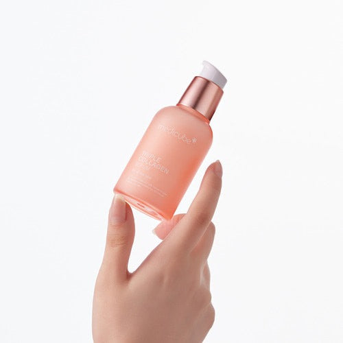 MEDICUBE Triple Collagen Serum 4.0 de Medicube, main tenant le flacon rose sur fond blanc minimaliste