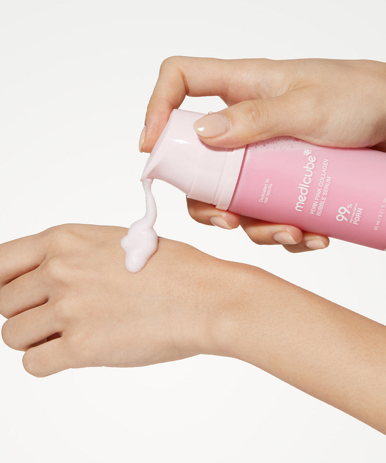 Application du sérum MEDICUBE PDRN Bubble Cream 95ml sur une main, montrant la texture mousseuse du produit.