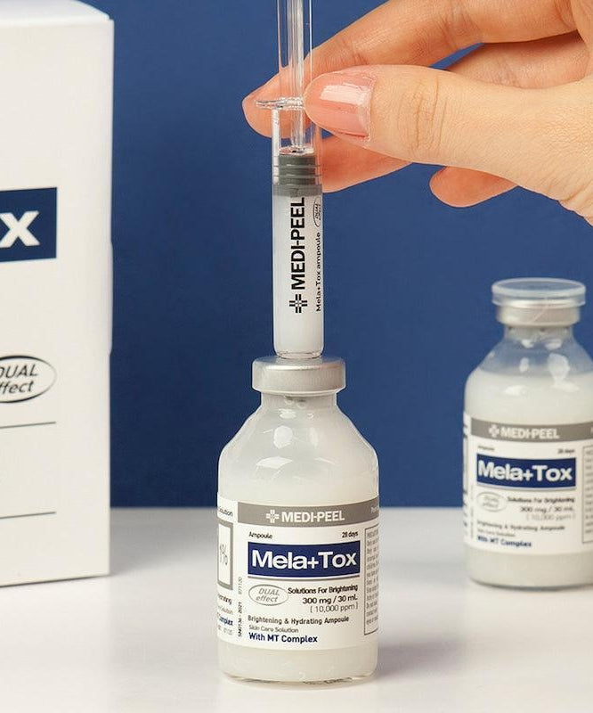 MEDIPEEL Mela Plus Tox Ampoule 35ml : main tient une ampoule, flacons MEDIPEEL sur fond bleu, contexte visuel beauté.
