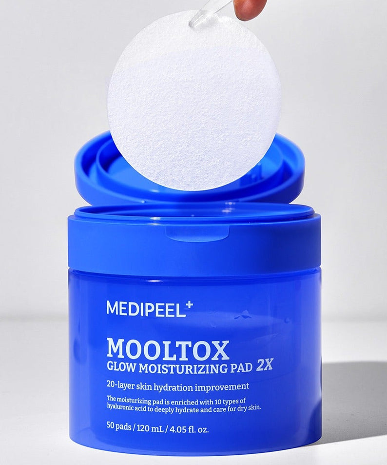 MEDIPEEL Water Tox Glow Moisturizing Pads 50 Sheets, pack bleu MEDIPEEL+ et pad blanc, sur fond clair, main tenant une pastille.