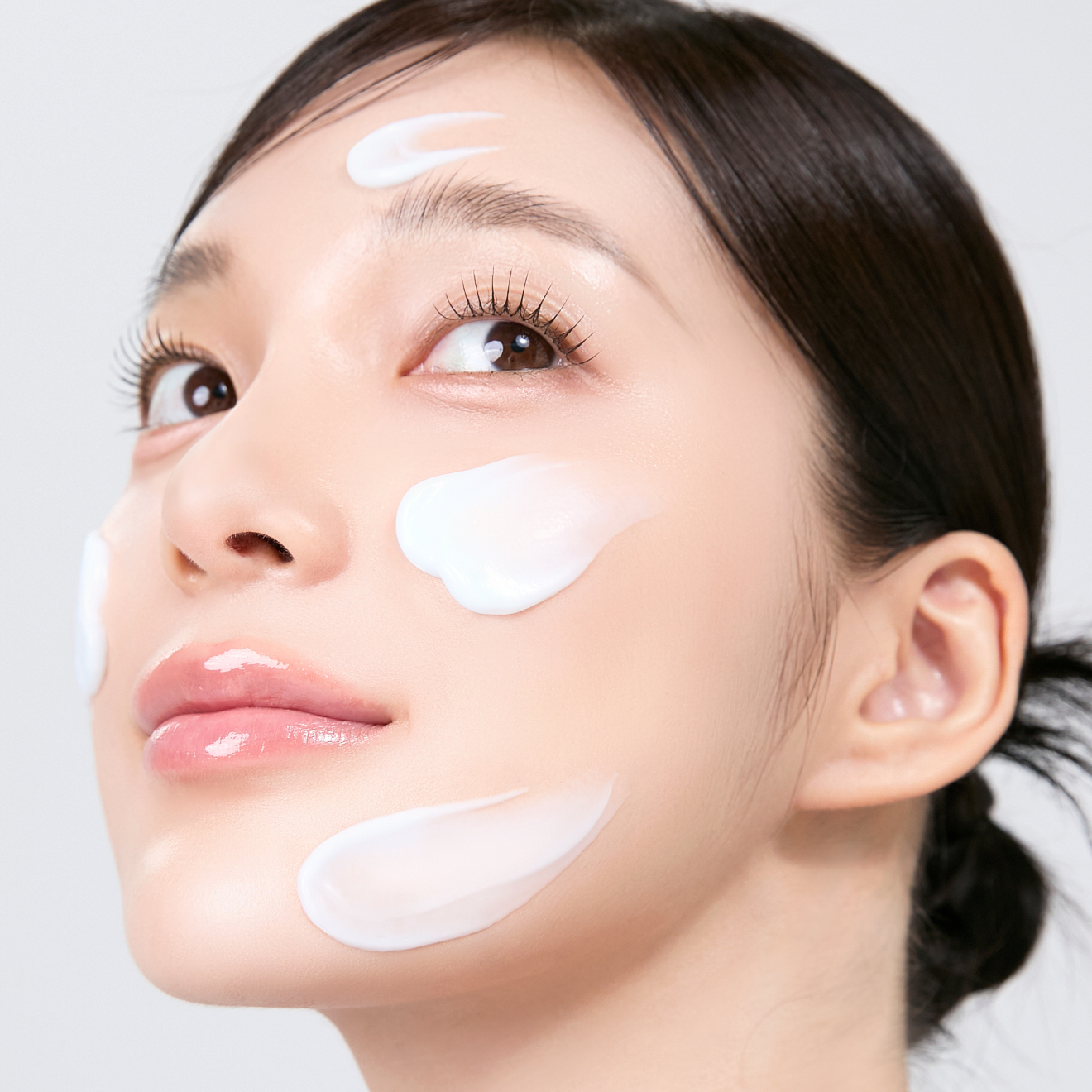 MEDITHERAPY Squalane Skin Booster Moisturizer 150ml : crème hydratante sur le visage, femme, gouttes blanches, fond clair.