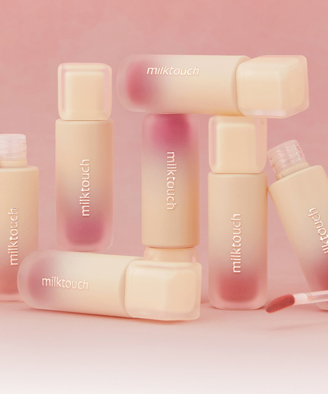 MILK TOUCH Spread Fit Blur Tint de la marque Milk Touch, flacons pastel maquillage sur fond rose doux.