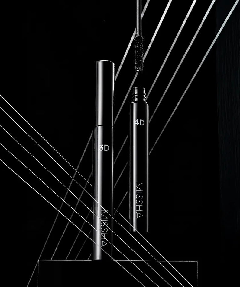 MISSHA  Mascara 7g (3D/4D) — flacons noir et argent sur fond sombre avec lignes lumineuses, décor promo.