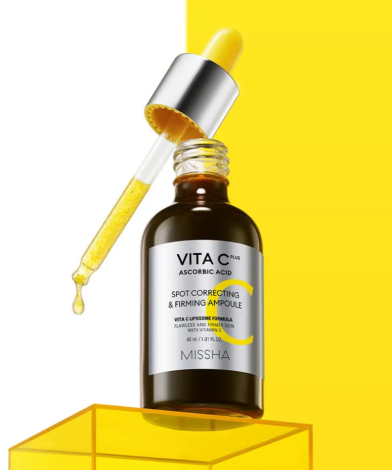MISSHA  Vita C Plus Blemish C Elasticity Ampoule 40ml : flacon avec goutte d’acide et fond jaune en studio.
