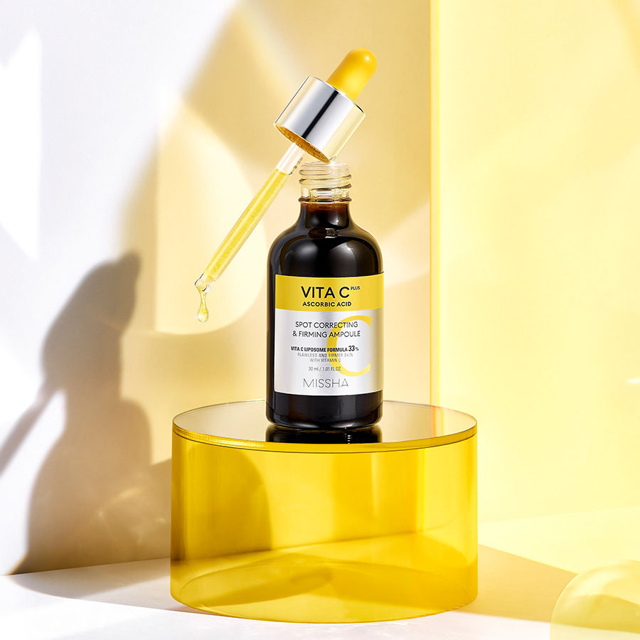 MISSHA  Vita C Plus Blemish C Elasticity Ampoule 40ml, flacon sérum jaune sur podium, ambiance lumineuse en studio