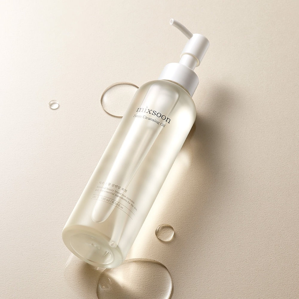 MIXSOON Bean Cleansing Oil 195ml, huile démaquillante de la marque Mixsoon sur fond crème, pompe blanche, gouttes et éclaboussures.