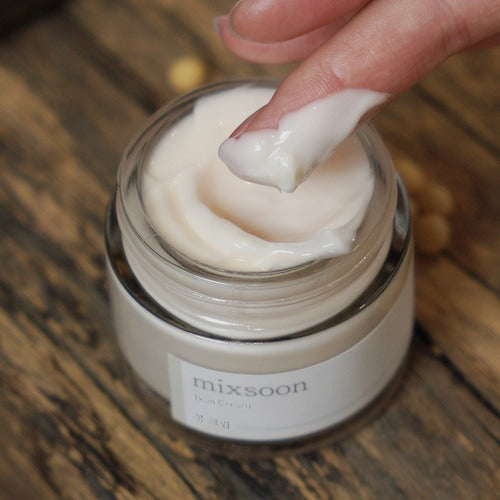 MIXSOON Bean Cream 50ml, pot de crème sur bois, texture blanche appliquée par une main, marque Mixsoon en gros plan.