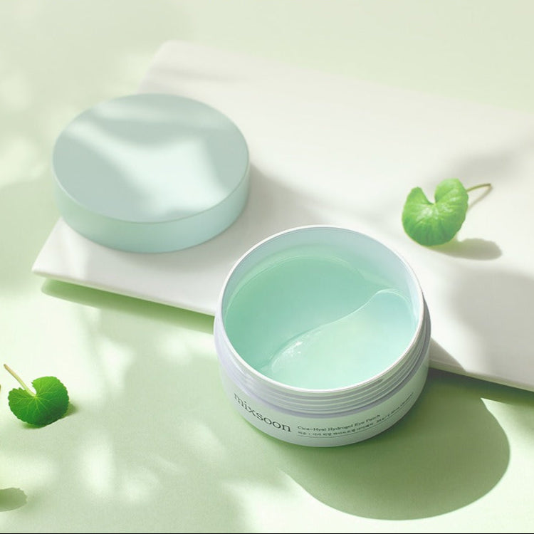 MIXSOON Cica Hyal Hydrogel Eye Patch 60 Sheets, marque sur fond clair avec pot et patches verts en contexte spa.