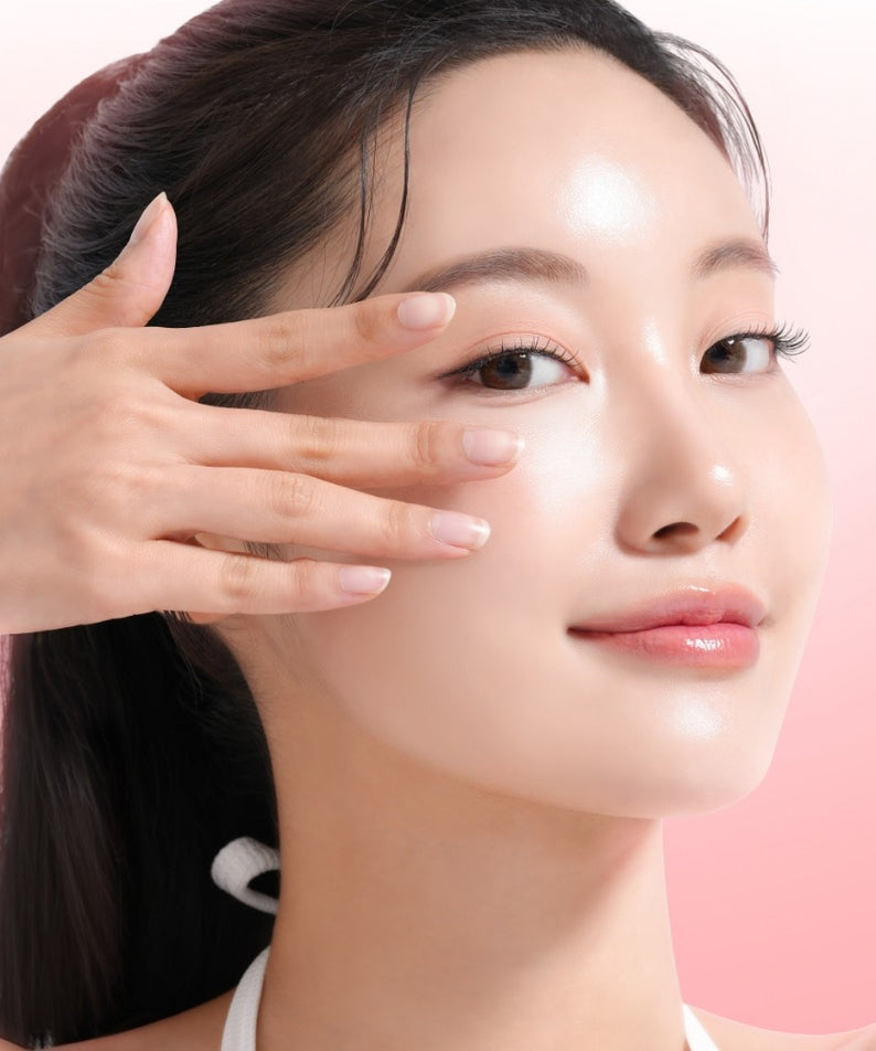 MIXSOON Collagen Hydrogel Eye Patch Single Pack 5 Sheets : femme applique un patch hydrogel sous l’œil, fond rose