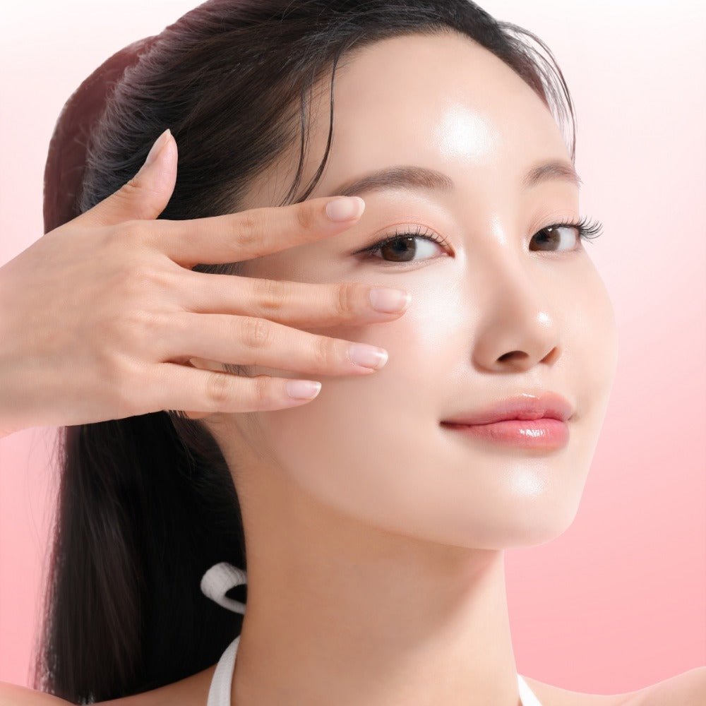 MIXSOON Collagen Hydrogel Eye Patch Single Pack 5 Sheets : femme applique un patch hydrogel sous l’œil, fond rose