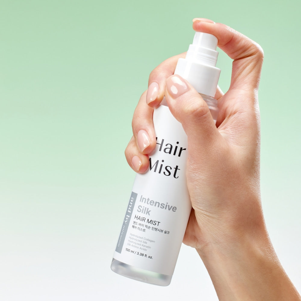 Main tenant MIXSOON Intensive Silk Hair Mist 100ml, flacon blanc sur fond vert, produit capillaire de la marque MIXSOON
