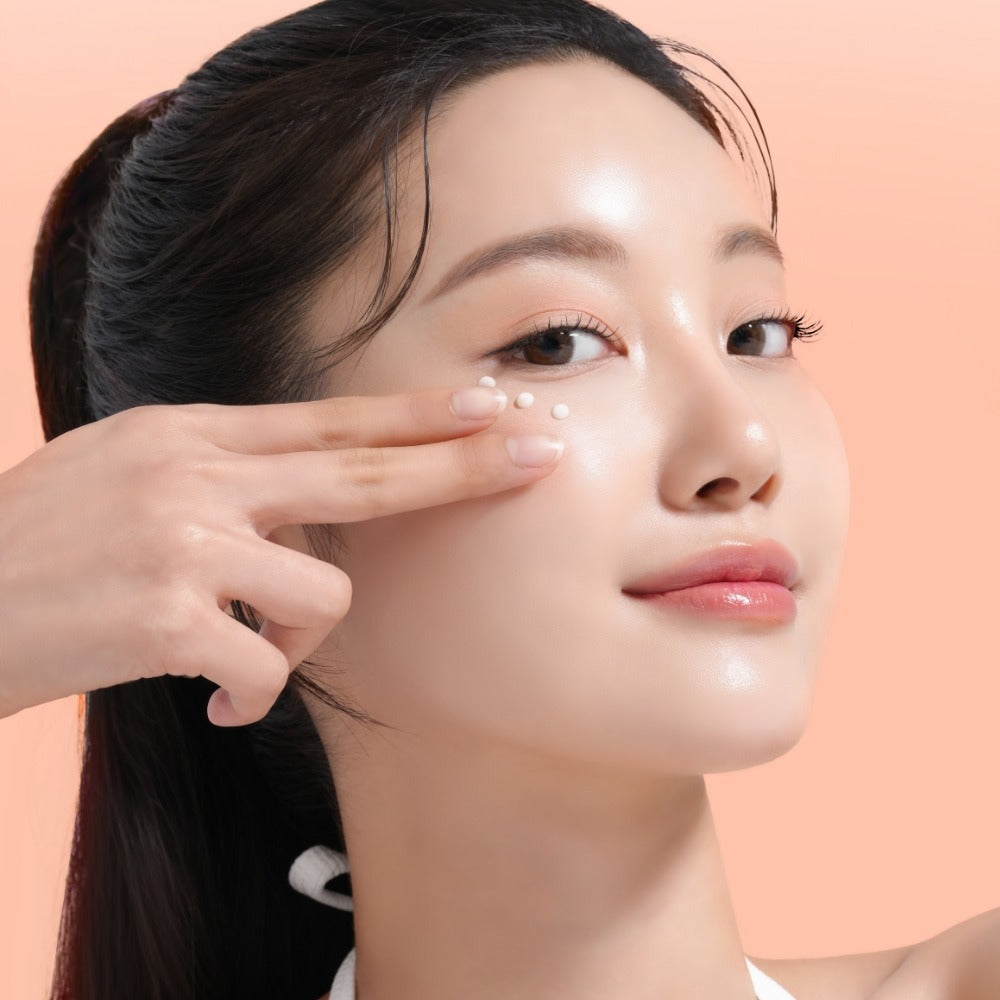 Décris l'image en français : MIXSOON PDRN Collagen Eye Serum 20ml, marque MIXSOON, femme applique au contour des yeux, fond rose.