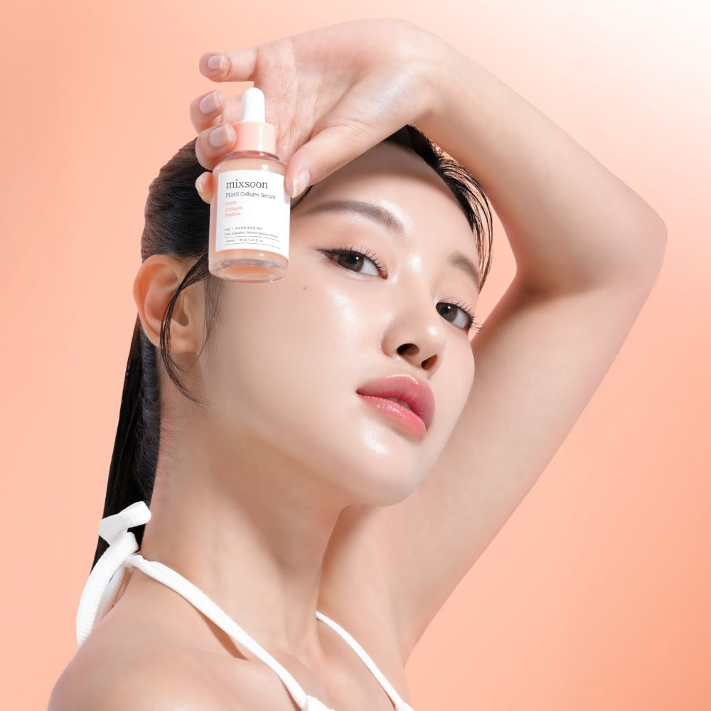 MIXSOON PDRN Collagen Serum 30ml, main applique sur visage, peau lumineuse, marque Mixsoon, fond rose pastel.