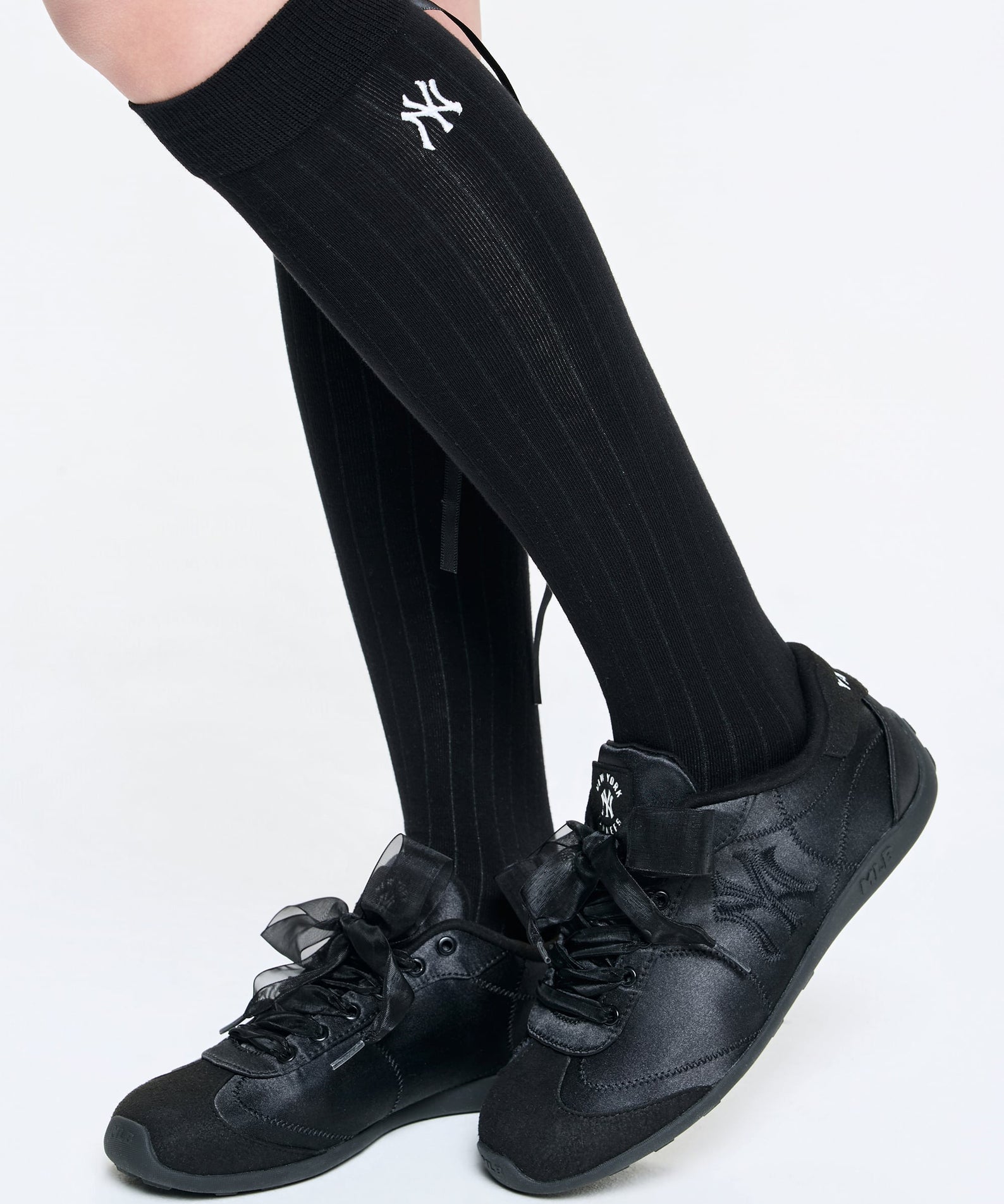 MLB Slick Powder New York Yankees BLACK : chaussettes noires Yankees sur jambes avec chaussures noires, sur fond clair.