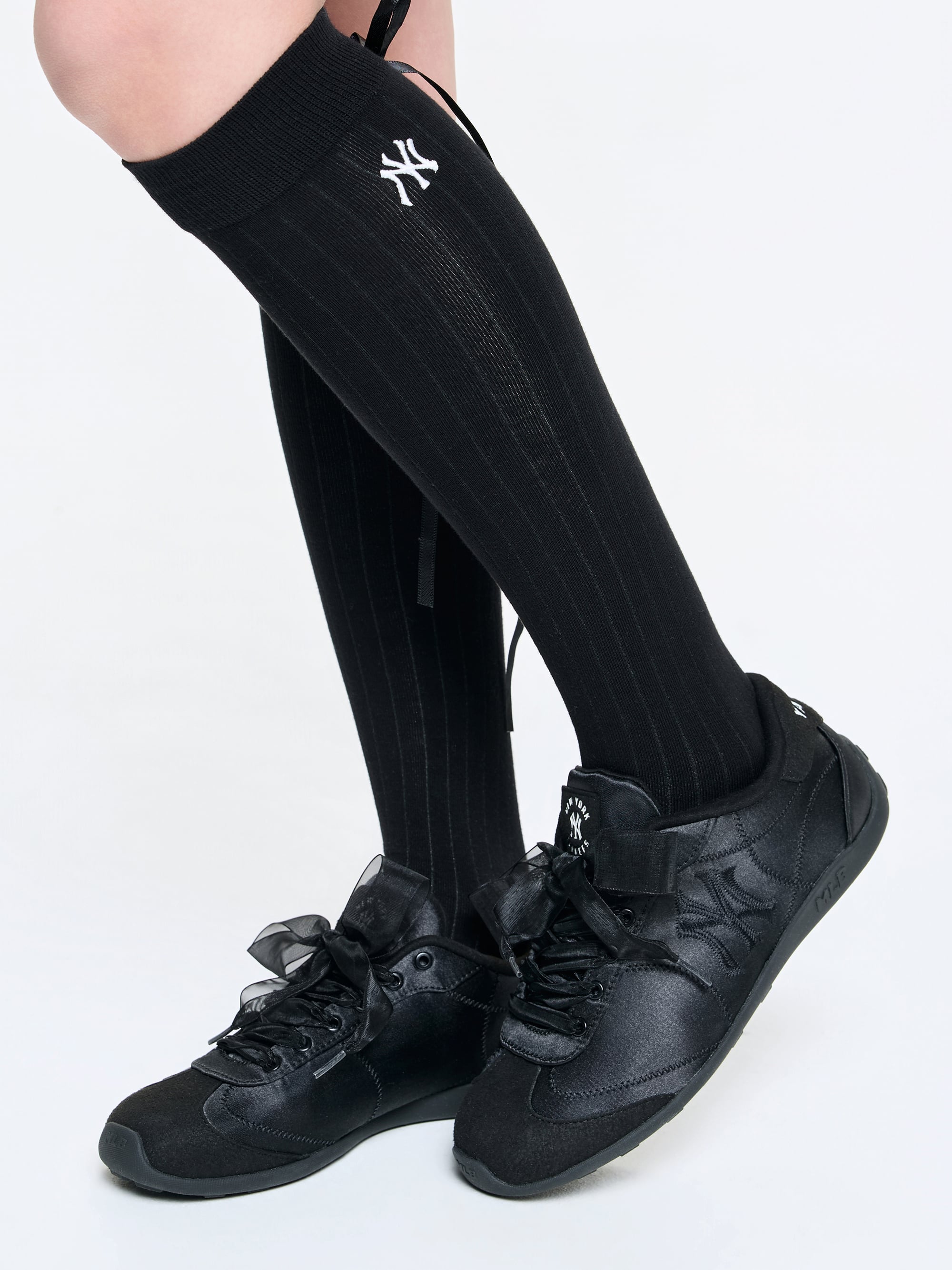 MLB Slick Powder New York Yankees BLACK : chaussettes noires Yankees sur jambes avec chaussures noires, sur fond clair.
