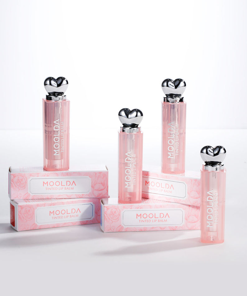 MOOLDA Tinted Lip Balm : packshots sur fond blanc, baumes teintés rosés de la marque MOOLDA, étalés en rangée.