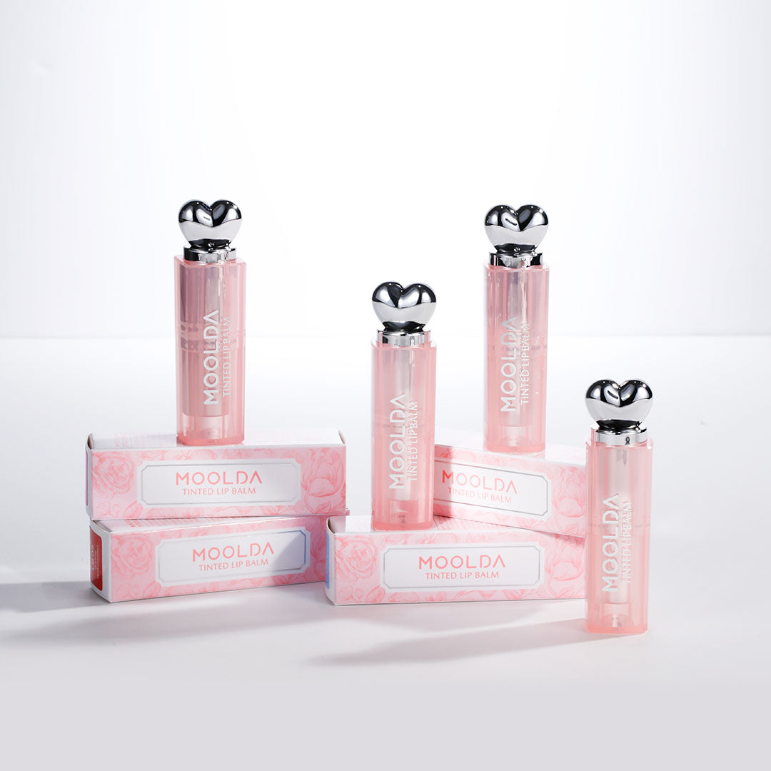 MOOLDA Tinted Lip Balm : packshots sur fond blanc, baumes teintés rosés de la marque MOOLDA, étalés en rangée.
