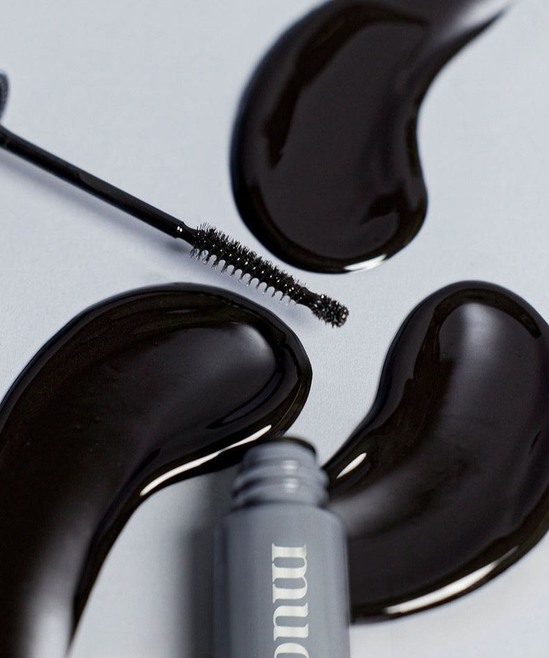 Sérum MUDE Eye Eye Ting Ting Serum Shot avec une brosse sur fond gris et taches brillantes.