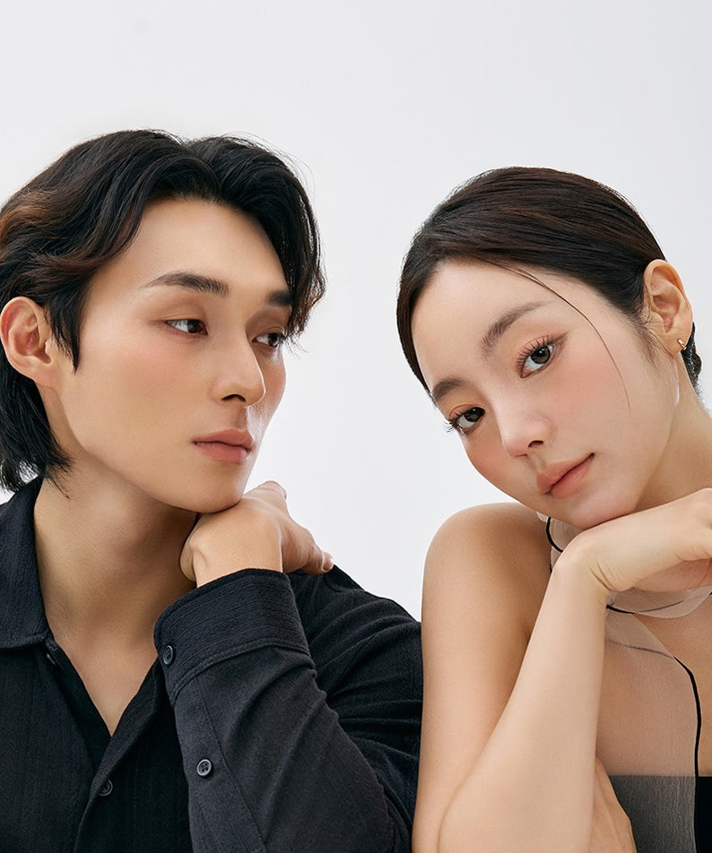 Portrait de deux personnes regardant dans des directions différentes sur fond blanc.