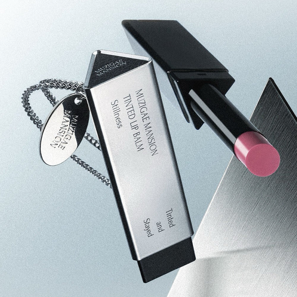 MUZIGAE MANSION Tinted Lip Balm, tube noir et baume rosé, marque MUZIGAE MANSION en gros plan sur fond clair