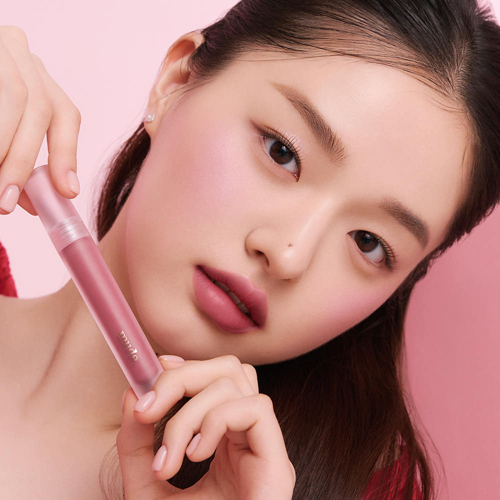 Mude Mood Soft Blur Tint par Mude, produit de teinte estompée sur fond rose, gros plan maquillage visage