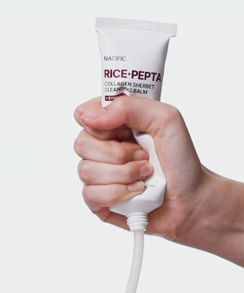 Main tenant NACIFIC Rice Pepta Collagen Sherbet Cleansing Balm 80g de NACIFIC, crème nettoyante sur fond clair.